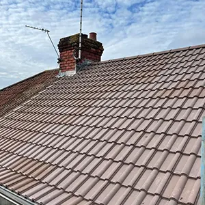 a roof with a chimney and a sky background