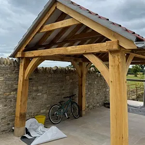 a wooden gazebo with a bicycle parked under it