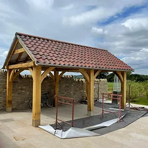 a wooden pavilion with a red tiled roof